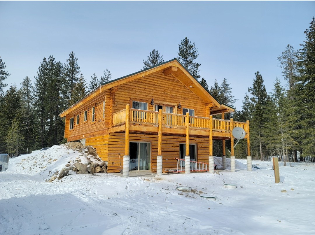 Two-story log home exterior with snow